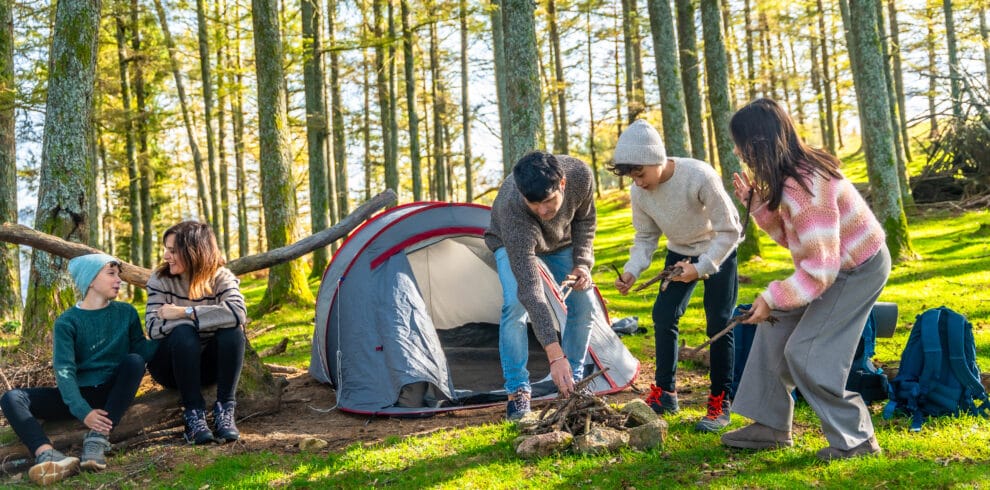 Family preparing campfire in front of the tent